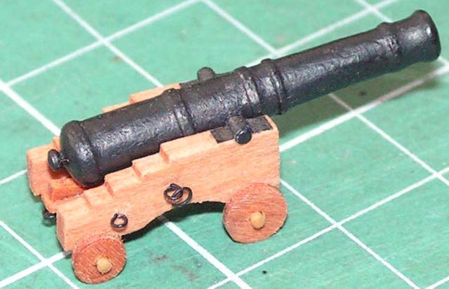Prototyp armaty. Lufa wykonana z kartonu, jedynie &quot;grzybek&quot; w tylnej części to szpilka. Laweta to klejony warstwowo fornir gruszy 0,6mm. Zaczepy z drutu miedzianego 0,2mm. Wnioski: Aby uzyskać większą gładkość, lufę dokładniej zalać super glue, a farbę rozrzedzić aby uniknąć smużeń. Koła lawety pogrubić o jedną warstwę forniru.